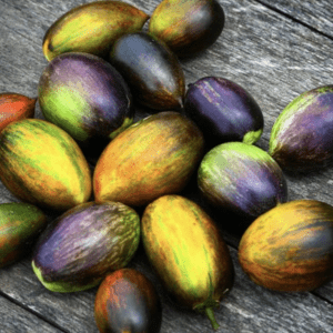 Colorful, ripe tamarillo fruits on a wooden surface.